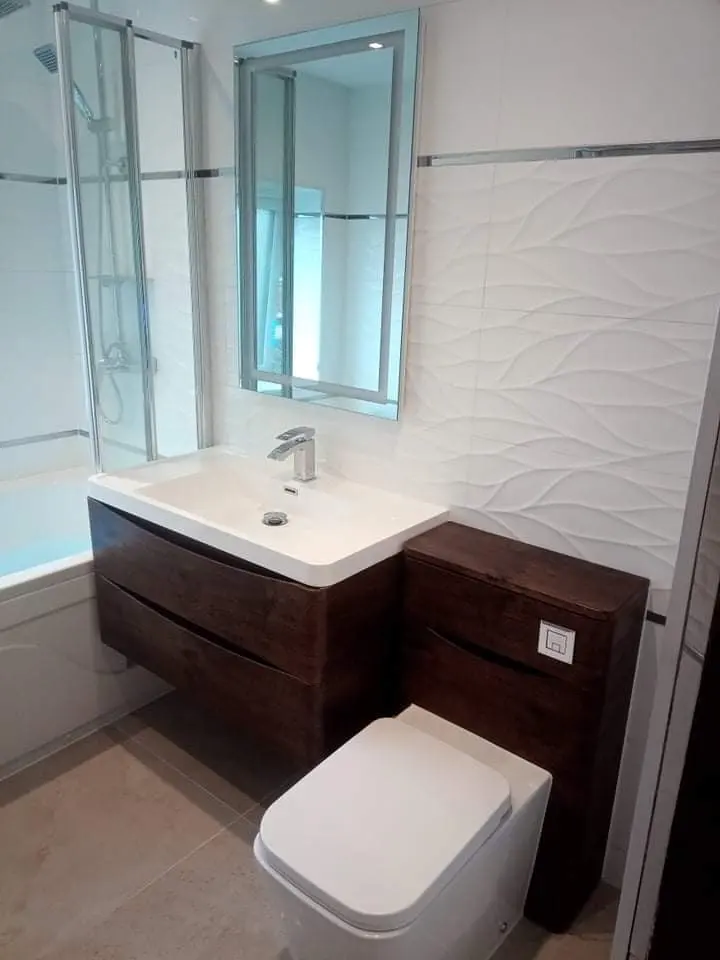 Bathroom with white wave-textured wall tiles, a dark wall-hung vanity and a mirror