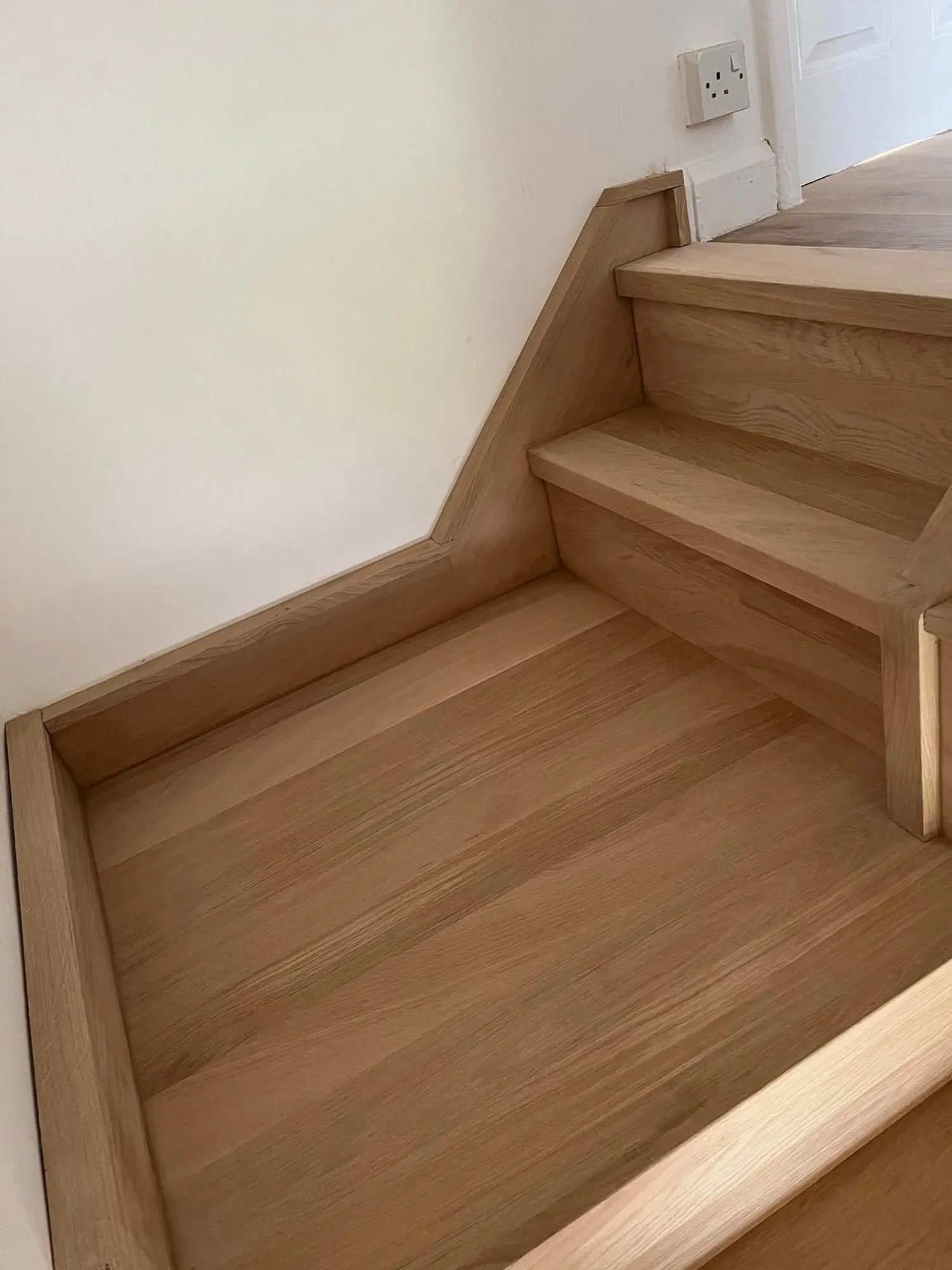 Oak-clad stair landing with a winder step