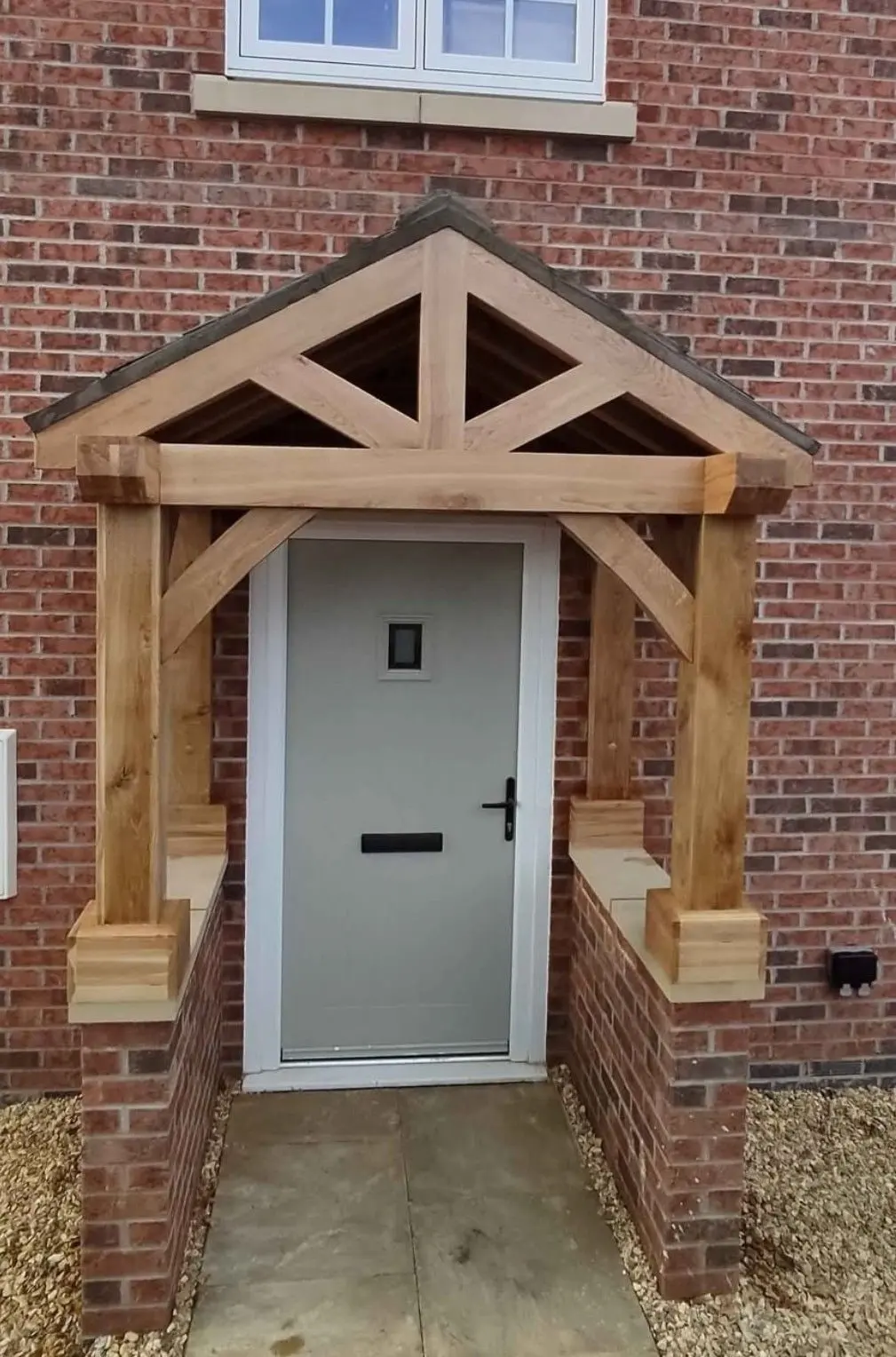 Oak-framed porch with a braced truss over a grey front door