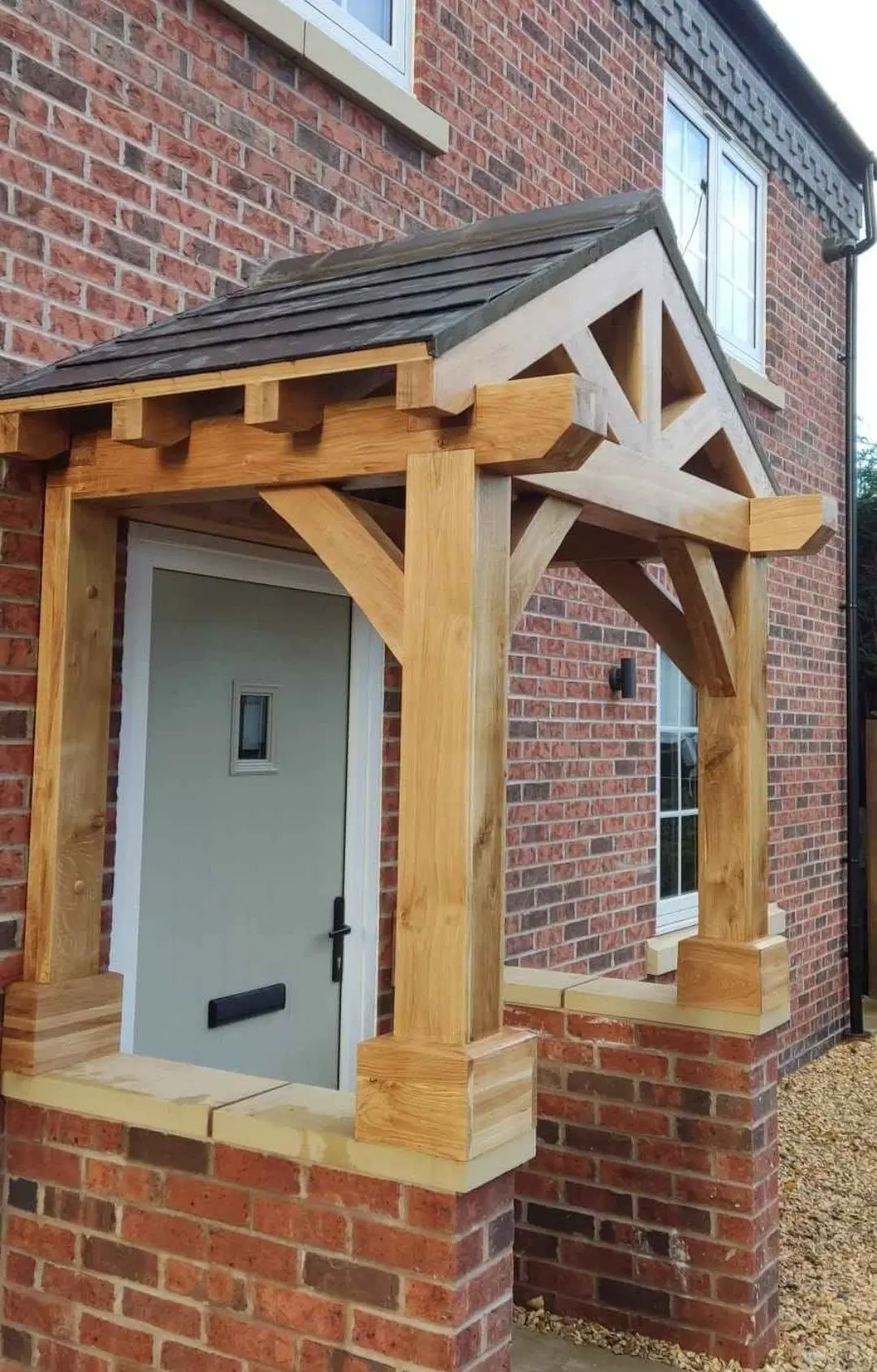 Oak porch with exposed rafter ends and a slate-effect roof