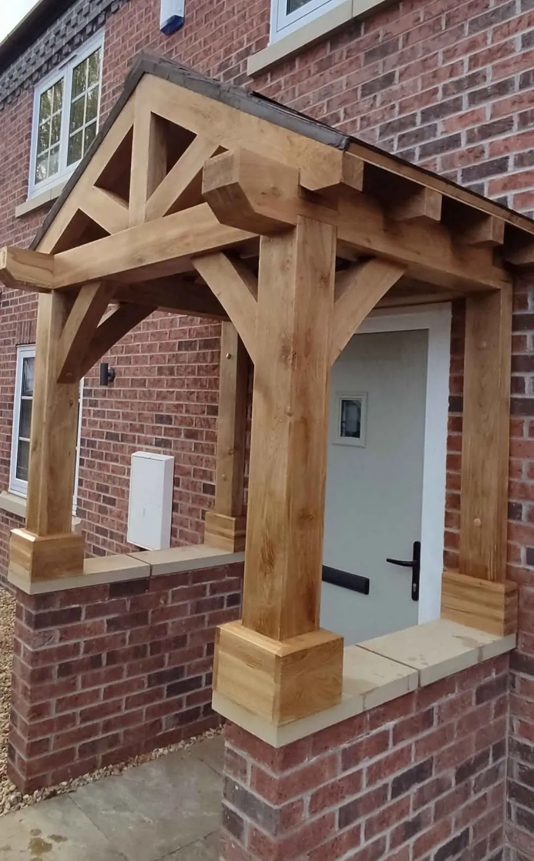 Oak porch with a king-post truss and oak posts on brick plinths