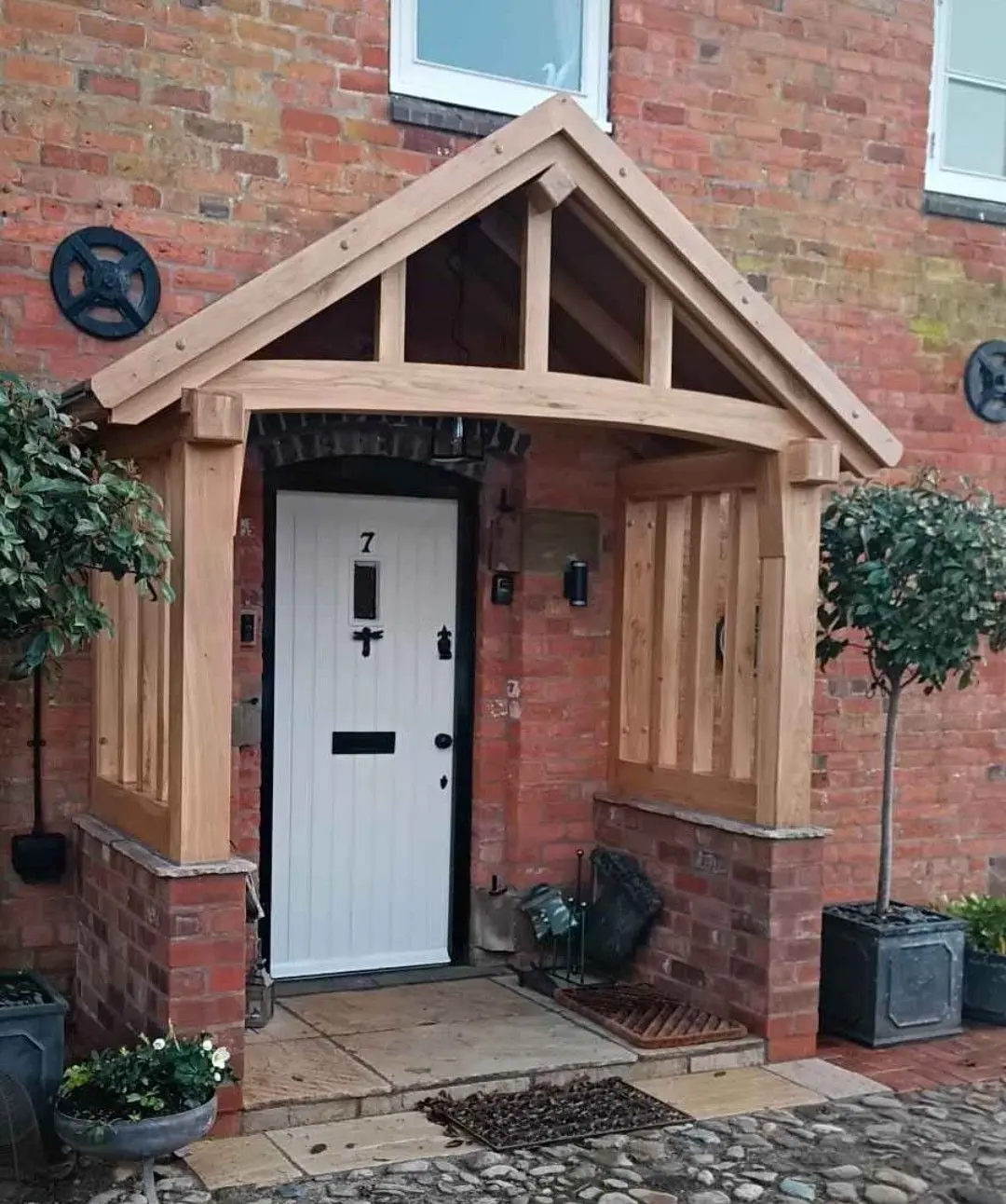 Oak porch with panelled sides over a white front door