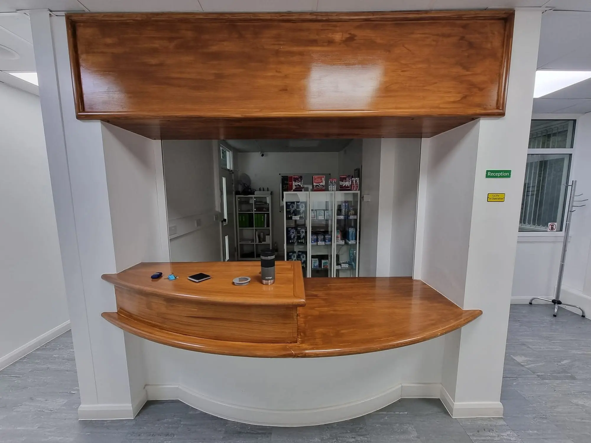 Curved oak reception counter with a panelled canopy above