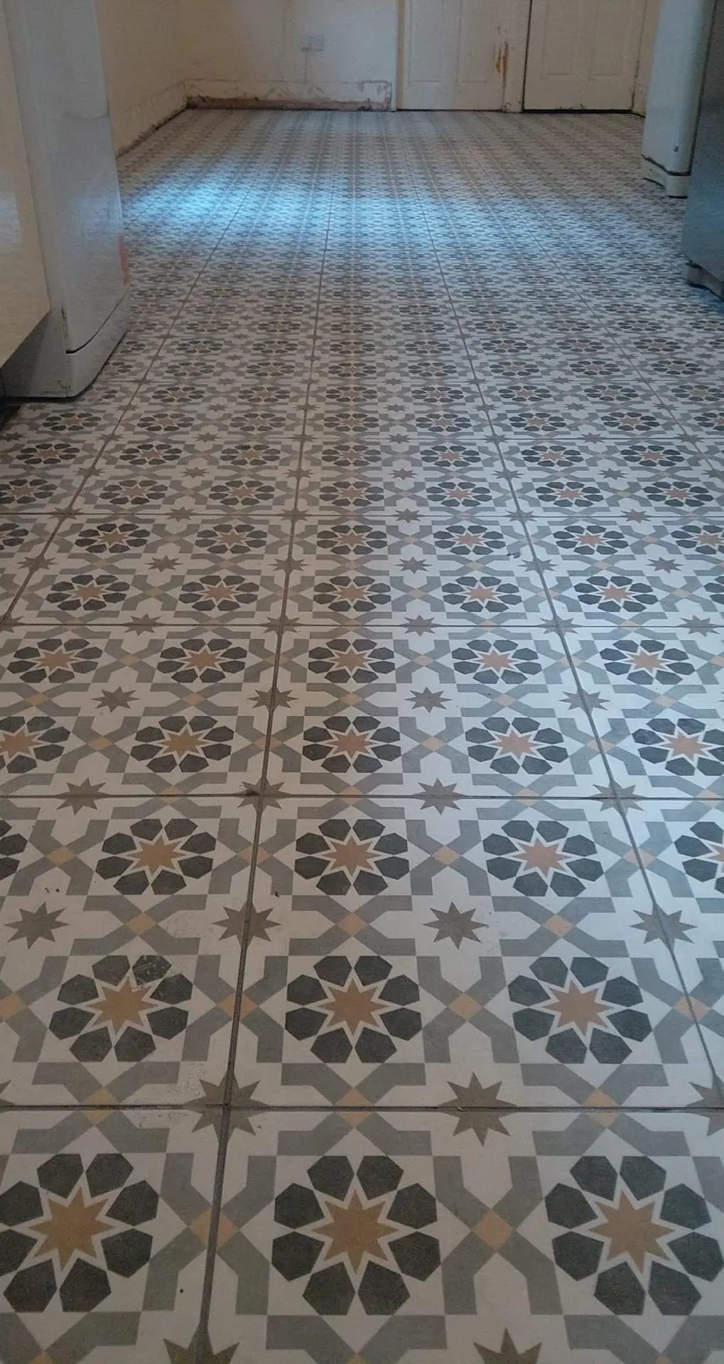 Long hallway laid with patterned floor tiles